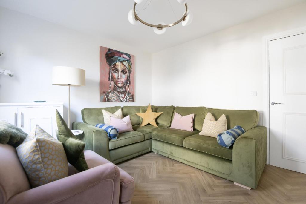 a living room with a green couch with pillows at The Rosemont in Royal Tunbridge Wells