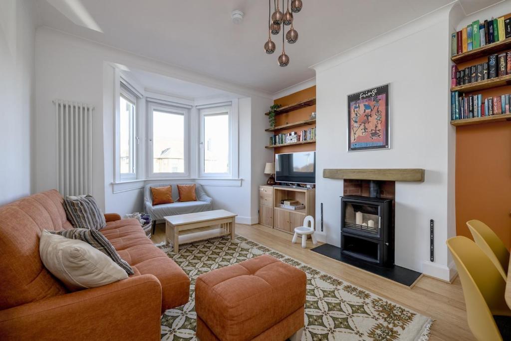 a living room with a couch and a fireplace at Barnton Grove Getaway in Edinburgh