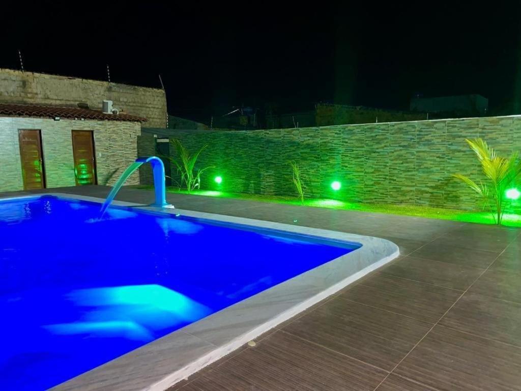 a swimming pool at night with green lights at Chácara Betel in Marechal Deodoro