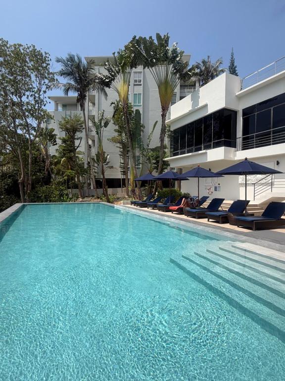 a large swimming pool with chairs and a building at Apartment Karon SeaView 72 sq in Karon Beach