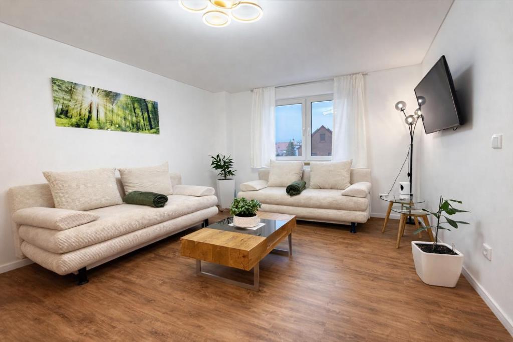 a living room with a couch and a table at Leipzig Lux Suites in Leipzig