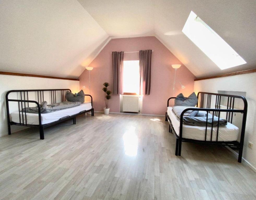 a attic room with two beds and a window at Ferienwohnung-Esel in Dreetz