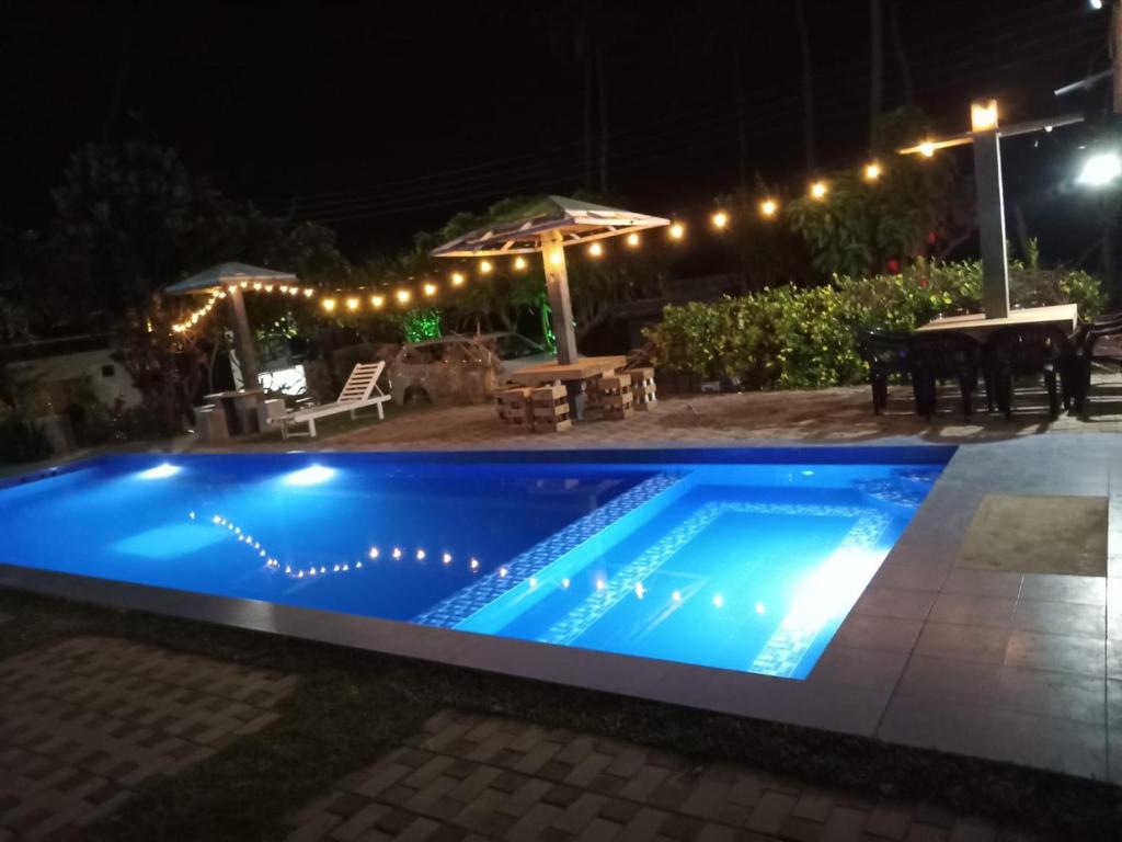 a swimming pool in a yard at night at Blu EDGE BEACH RESORT in Katuneriya