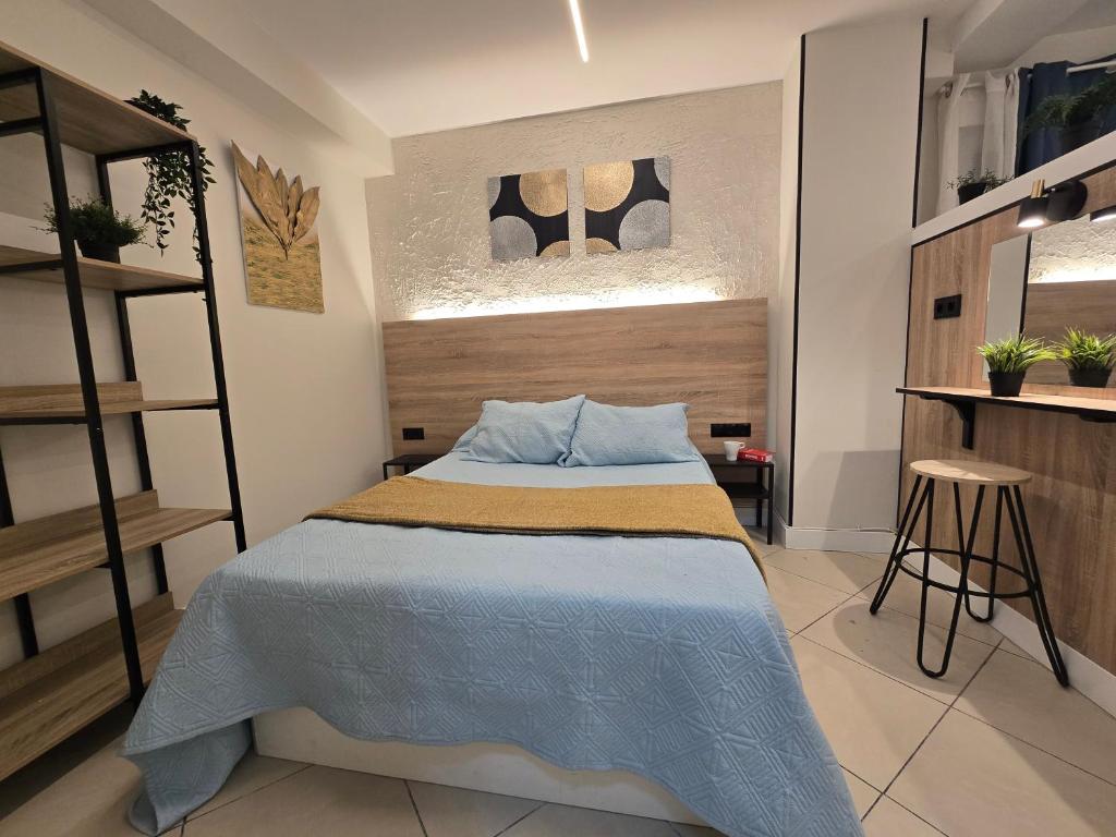 a bedroom with a bed with a blue blanket at Estudios Céntricos 65 in Santander