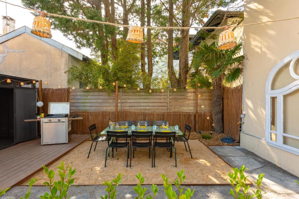 a patio with a table and chairs in a backyard at MISVA KEYWEEK Architect-designed flat in Biarritz with garden in Biarritz