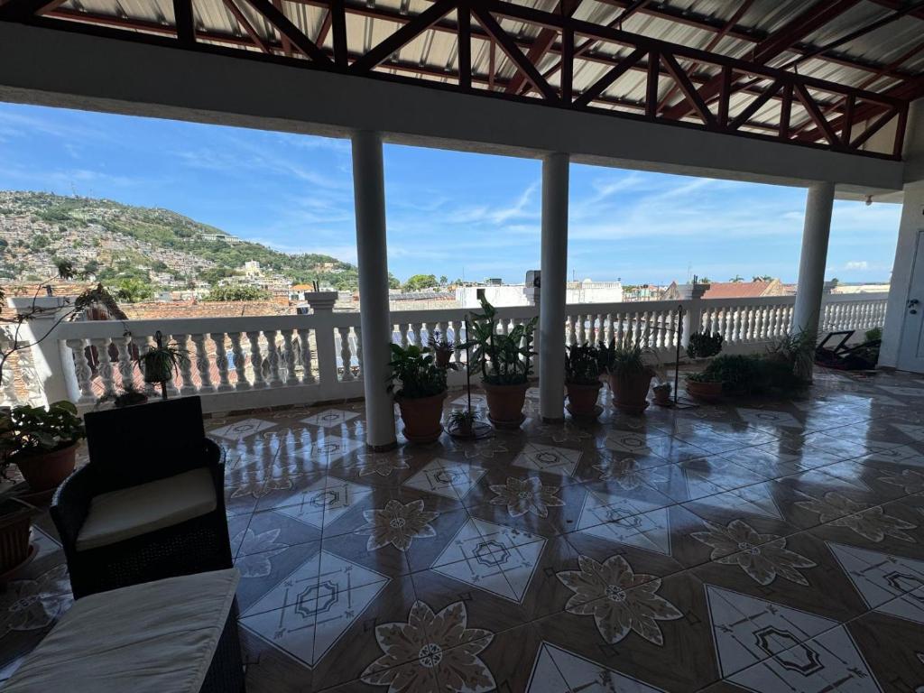 a balcony with potted plants and a view of a city at Preloune Residences SA in Cap-Haïtien