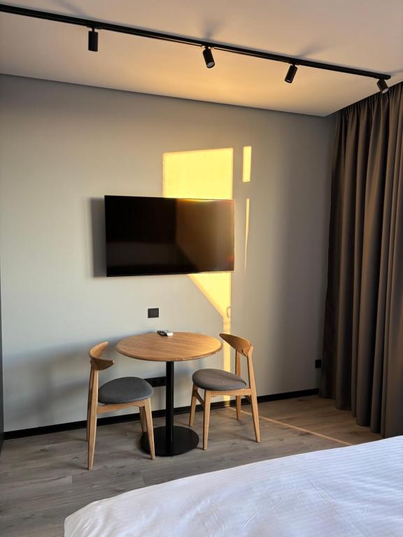 a room with a table and two chairs and a tv at Bavaro apartments 3 in Ivano-Frankivsk