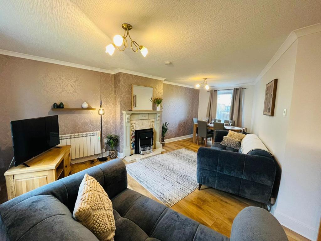 a living room with a couch and a television at Inas Place in Caol