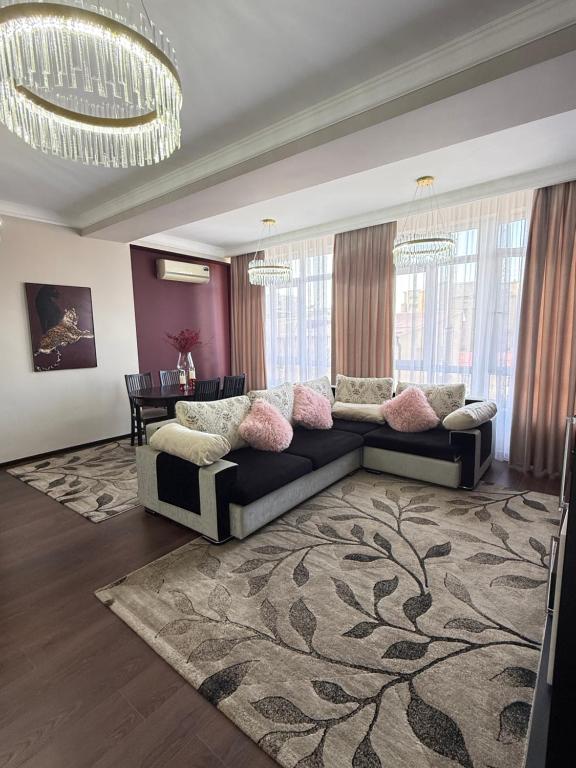 a living room with a couch and a table at Ala-Too Central Square Residence in Bishkek