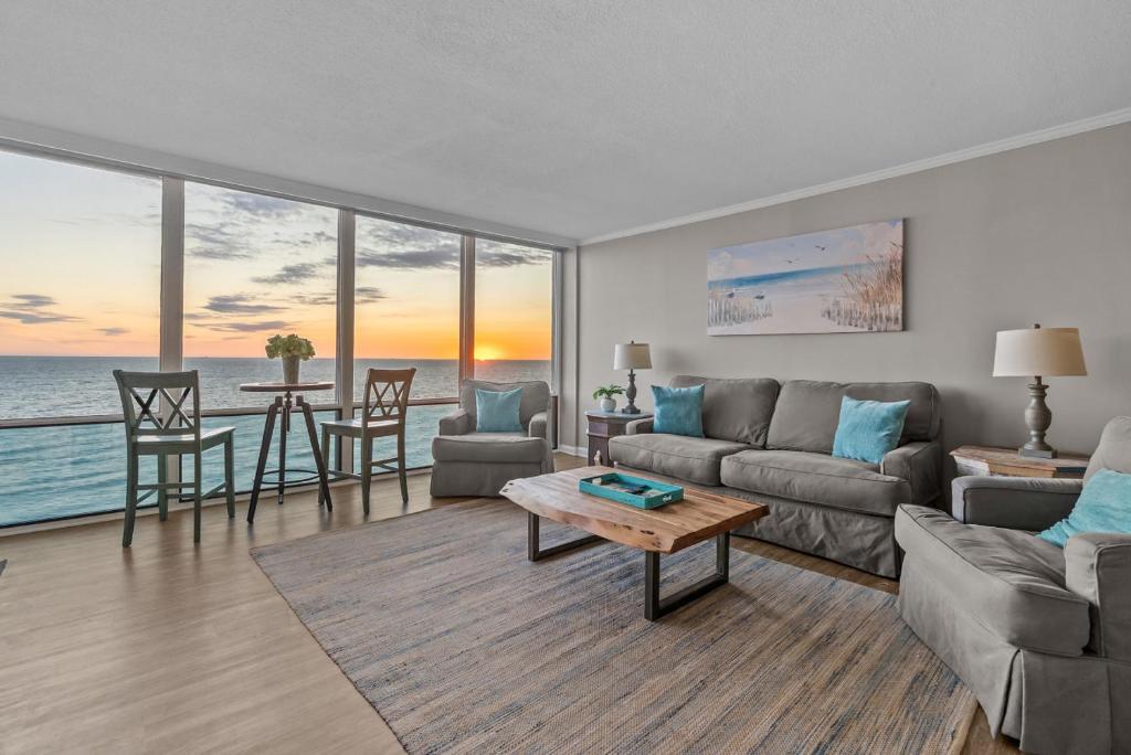 a living room with a couch and a table at Beachfront Condo/ Pool/ Surfing/ Fishing / EW 1202 in Virginia Beach