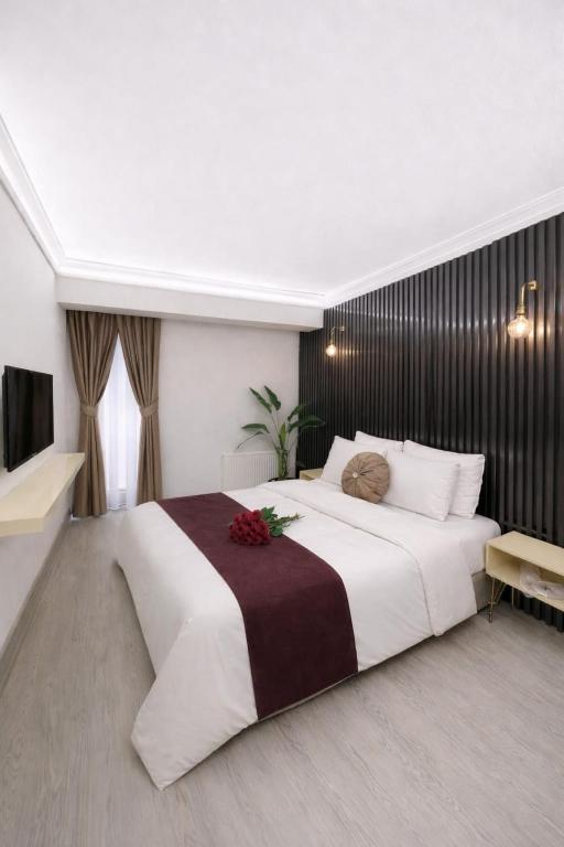 ein Schlafzimmer mit einem großen weißen Bett, das mit Blumen bedeckt ist in der Unterkunft Zebra Hotel Buca in Izmir