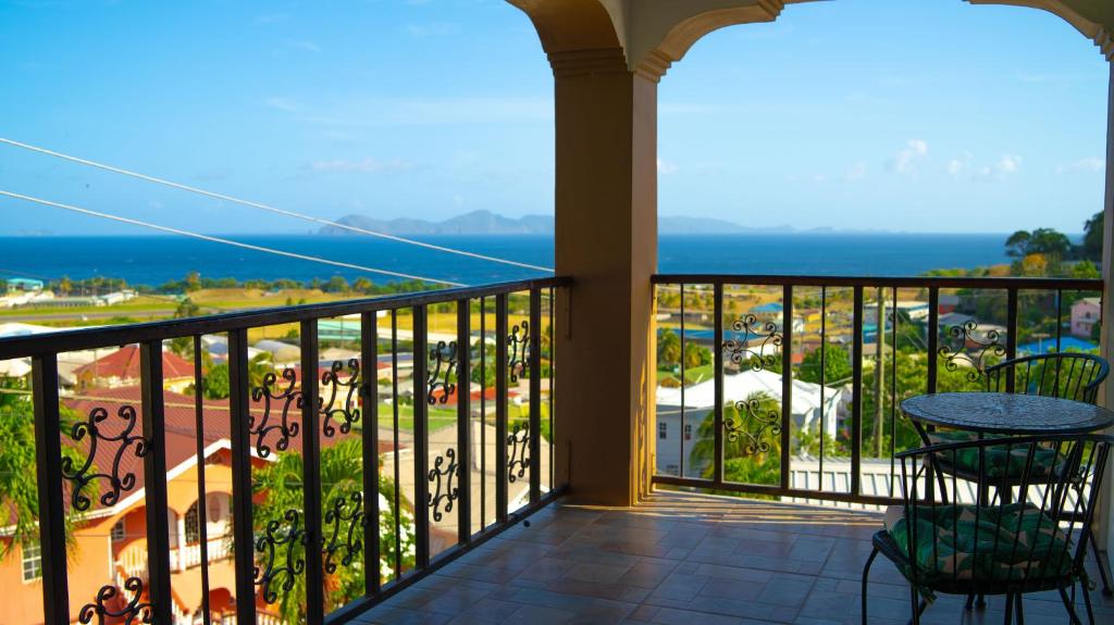 a balcony with a table and chairs and the ocean at Ahra Suites First Floor with ocean view in Kingstown