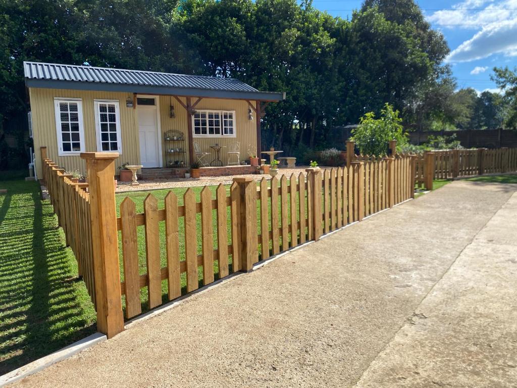 a wooden fence in front of a small house at Buttercup Cottage in Nottingham Road