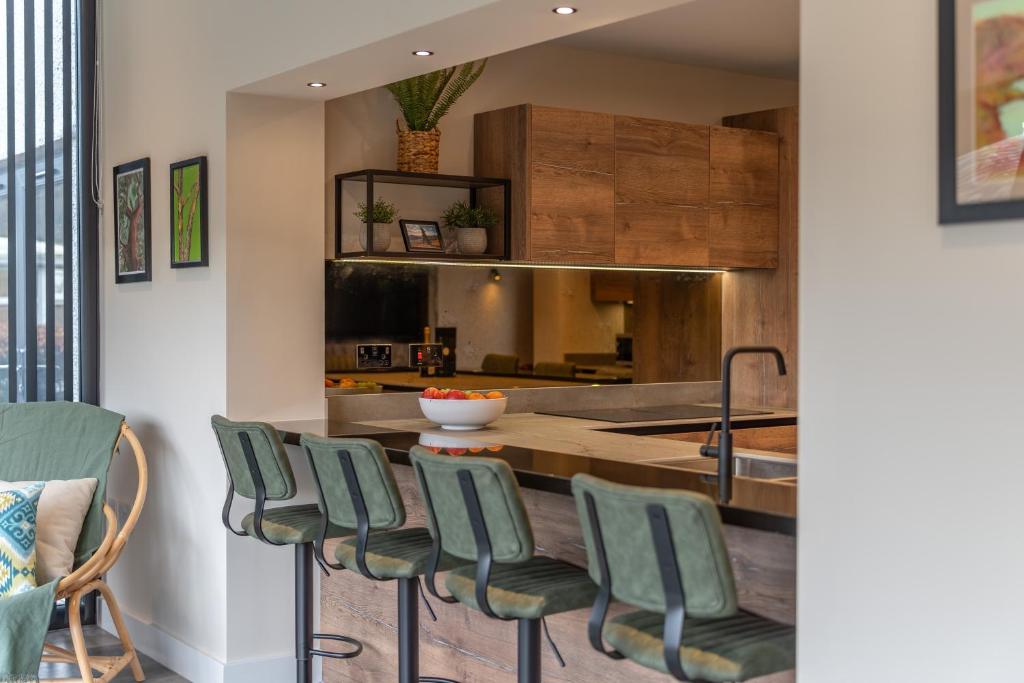 a kitchen with a table and green chairs at Elder howe in Penrith