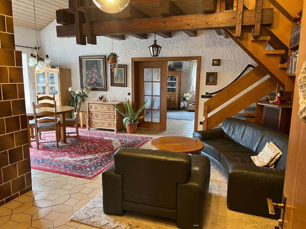 a living room with a couch and a table at Ferienhaus Natternberg Spacious apartment large living room 4 bedrooms garden quiet near Deggendorf in Deggendorf