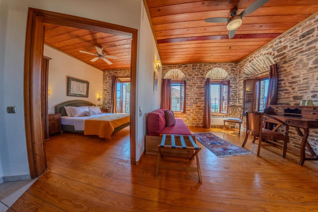 a bedroom with a bed and a table in a room at xenonas ton xromaton - Guest house of colors in Lafkos