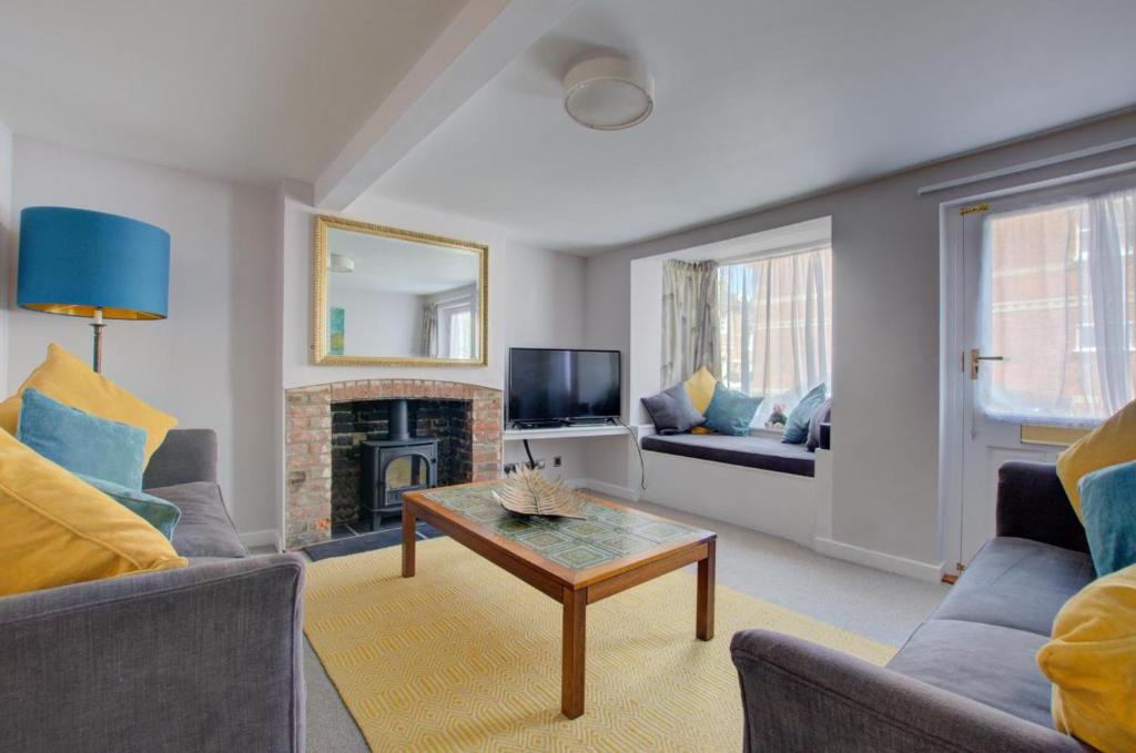 a living room with a couch and a fireplace at 5 Bed in Southwold oc-hjames in Southwold