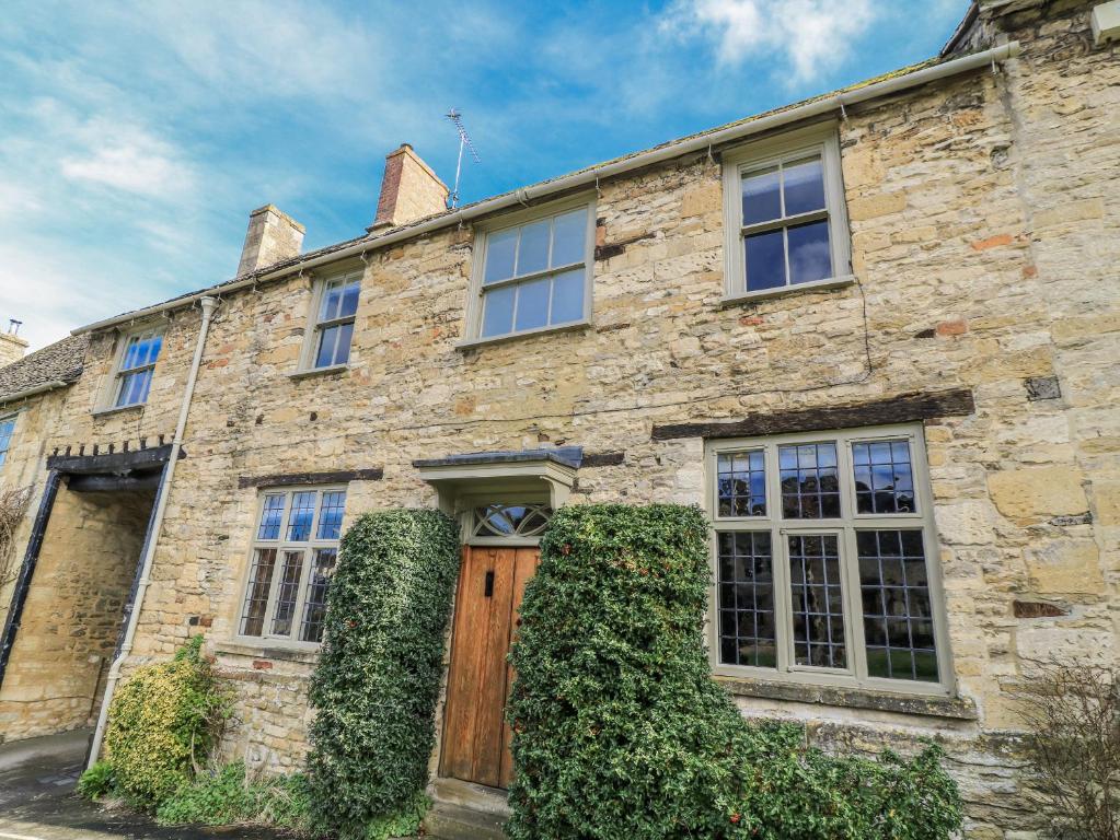 an old stone house with a wooden door at Ostlers in Burford