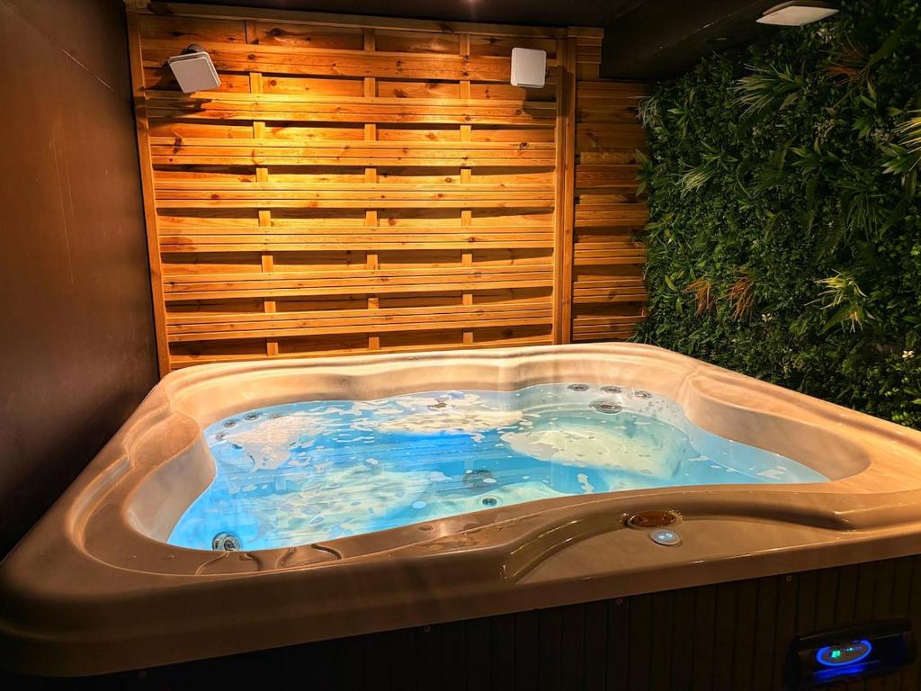 a jacuzzi tub in the middle of a room at Le Cocon de Rose & Achille in Boulogne-sur-Mer