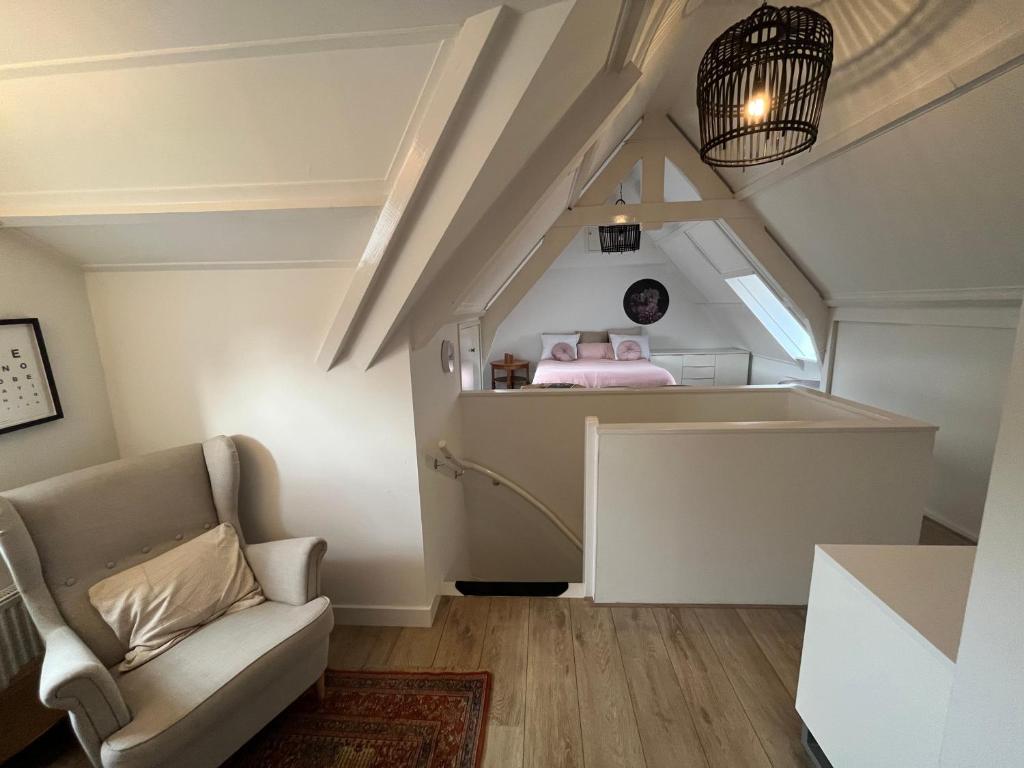 a living room with a couch and a pink bed at B&B De Holevoet in Scherpenzeel