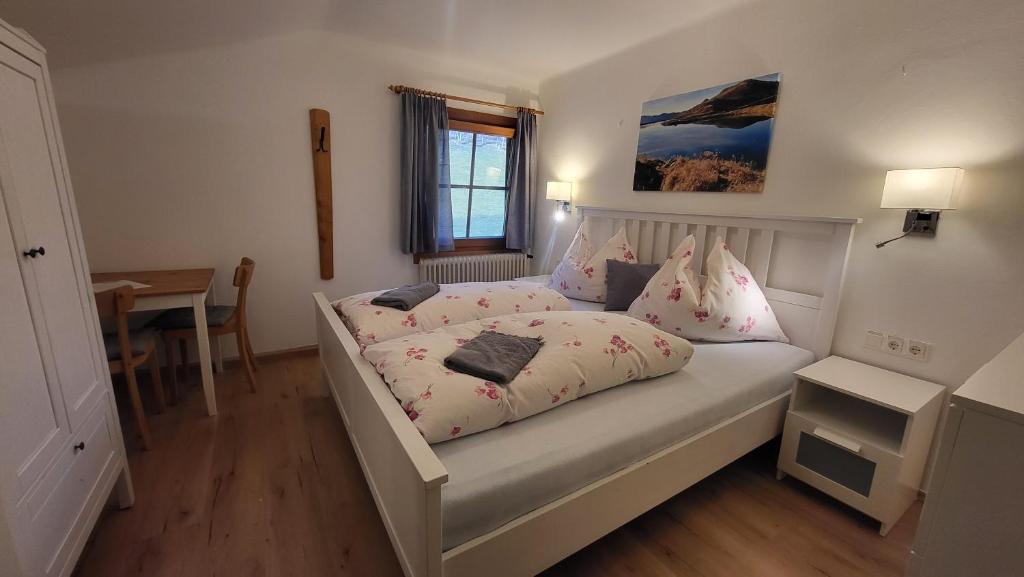 a bedroom with a white bed with pink pillows at Stefflhof Mittersill in Mittersill