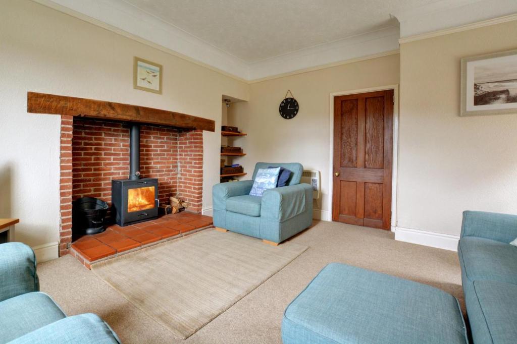 a living room with a couch and a fireplace at 2 Bed in Blakeney oc-1805 in Blakeney