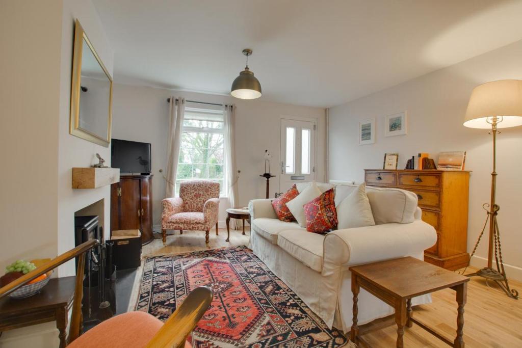 a living room with a white couch and a fireplace at 2 Bed in Dersingham oc-2154 in Dersingham