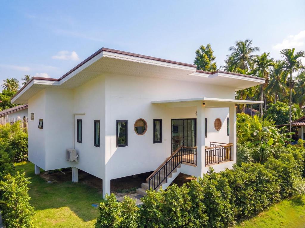 a small white house with a garden at Garden Villa in Srithanu