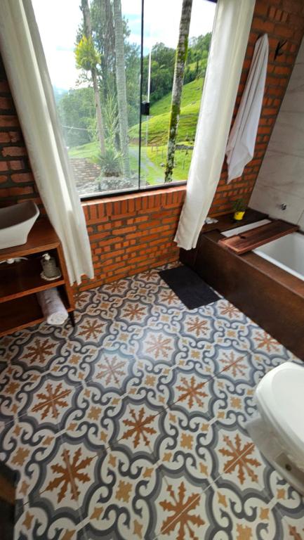 a bathroom with a toilet and a window at Chalé lindo e confortável! in Massaranduba