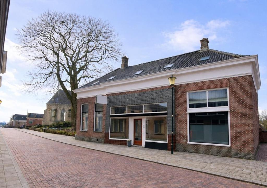 a brick building on the side of a street at Het Ambachtshuis Warffum in Warffum