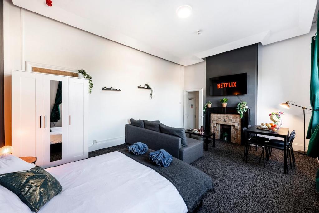 a bedroom with a bed and a couch and a fireplace at Spacious City-Centre Apartment · Sleeps 4 in Nottingham