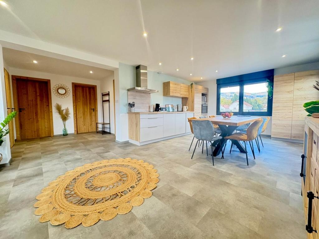 a kitchen and dining room with a table and chairs at Le Gite des Fleurs in Ramonchamp