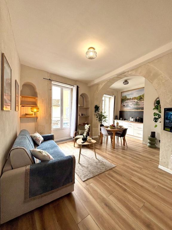 a living room with a couch and a table at CLIM - Hypercentre - Arche en pierre in Nîmes