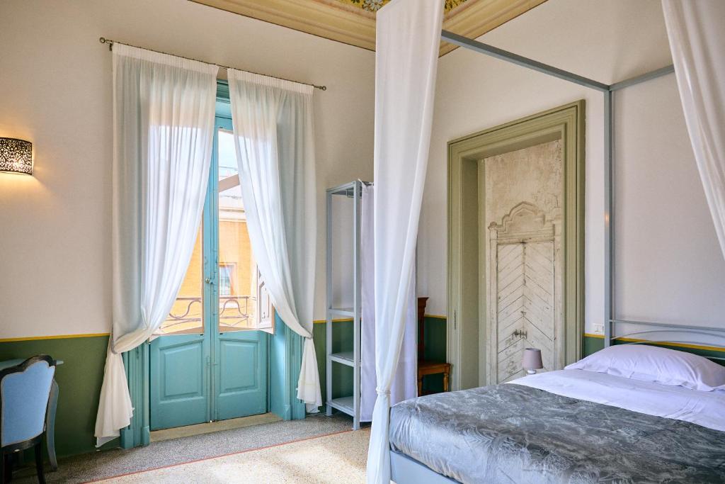 a bedroom with a canopy bed and a window at Palazzo Mercanzia in Lecce