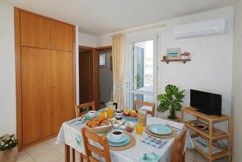 a dining room with a table with food on it at Attico Fronte Mare in Torre Mozza