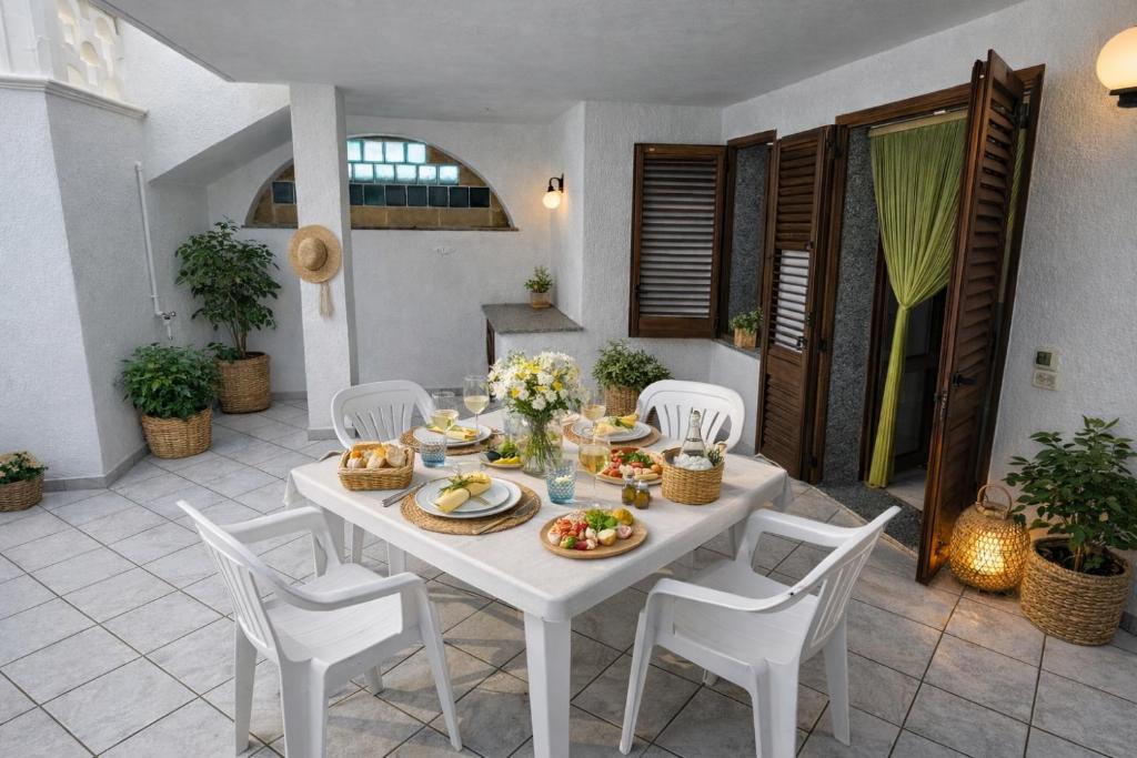 a white table and chairs with food on it at Casa Saracino 3 - Semplicità Mediterranea in Marina di Pescoluse