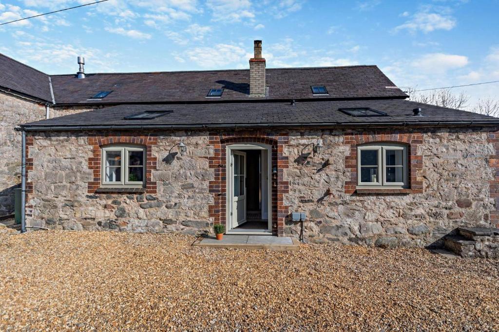 a stone house with a door on a gravel yard at 1 Bed in Cilcain oc-s29009 in Cilcain