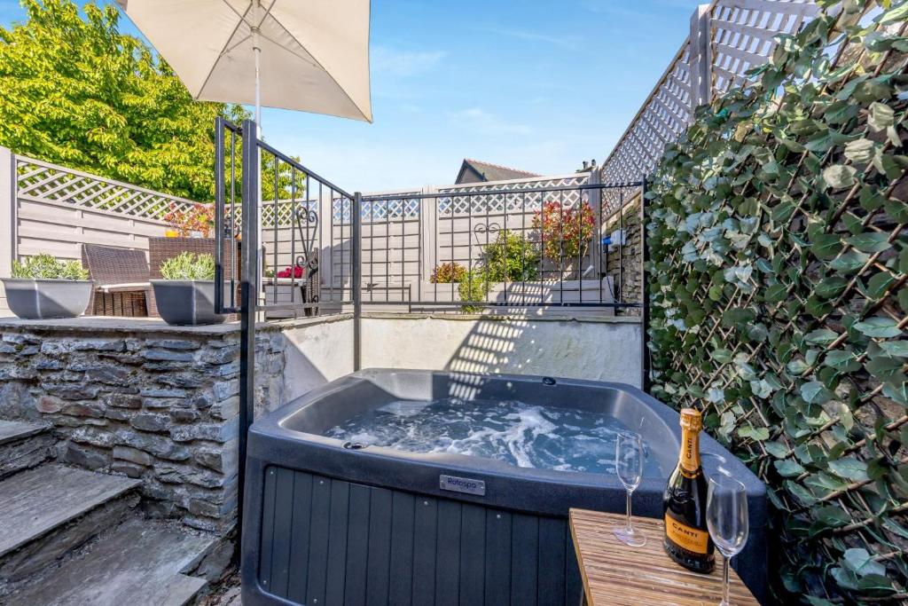 a hot tub on a patio with an umbrella at 1 Bed in Cerrigydrudion oc-bow194 in Cerrig-y-Druidion