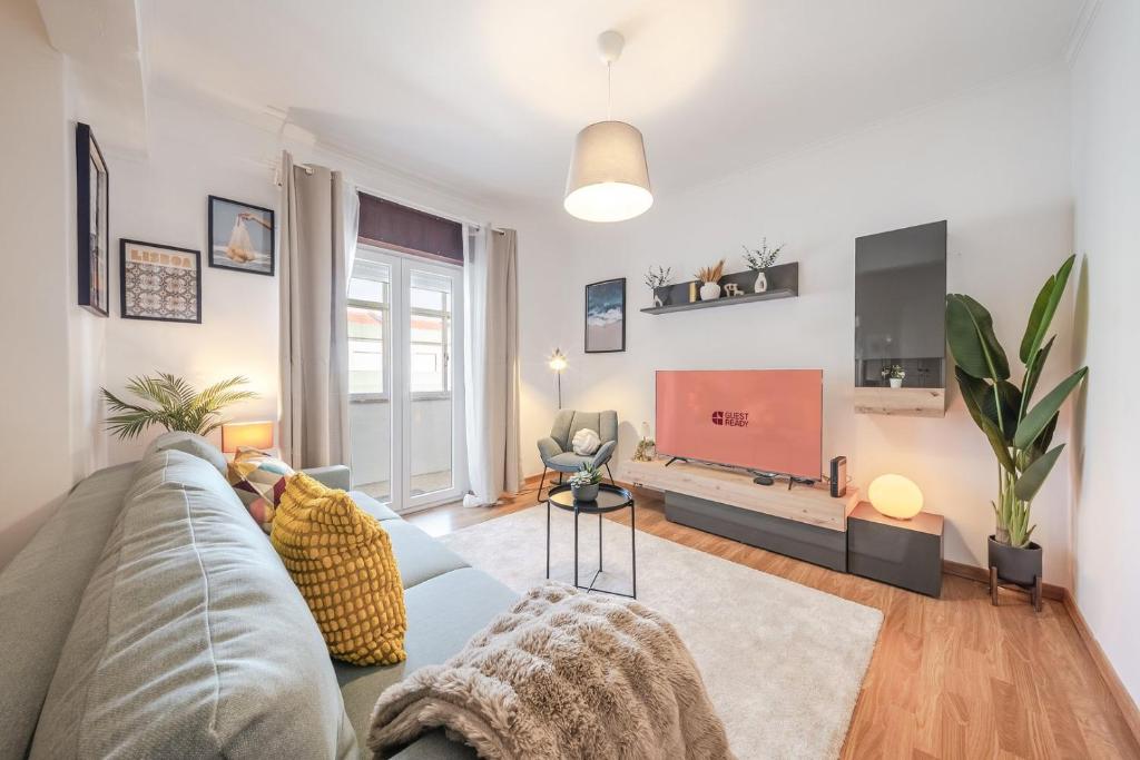 a living room with a couch and a flat screen tv at GuestReady - Charming Oeiras apartment in Oeiras