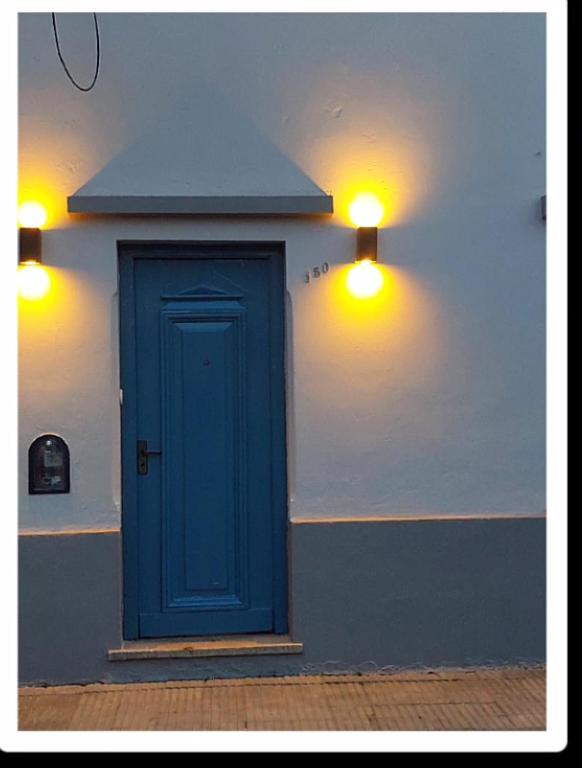 a blue door on the side of a building with lights at Lo de Mingo in San Pedro