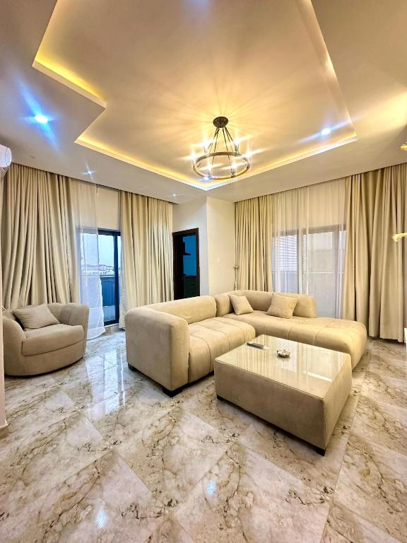 a large living room with a couch and a table at One bedroom apartment Presidential suite in Abuja