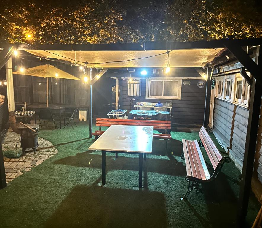 a patio with a table and benches at night at Casa en Lota central con tinaja in Lota