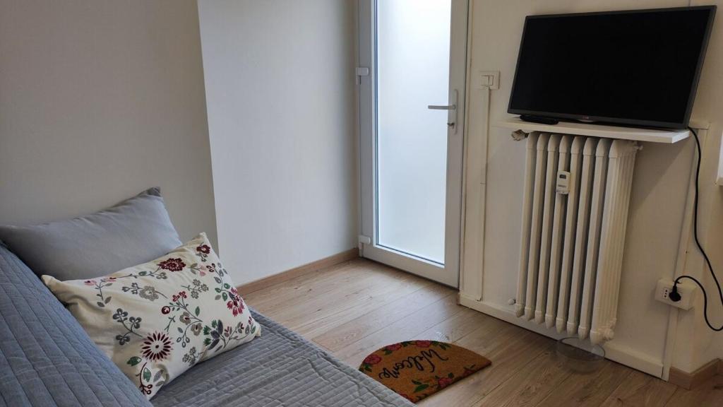 a living room with a couch and a television and a radiator at Torino Comfort 10 in Turin