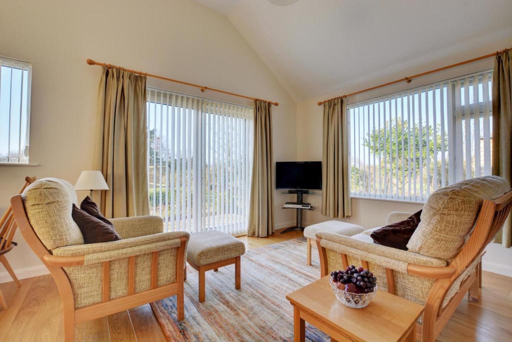 a living room with two chairs and a tv at 2 Bed in Attleborough oc-1277 in Old Buckenham