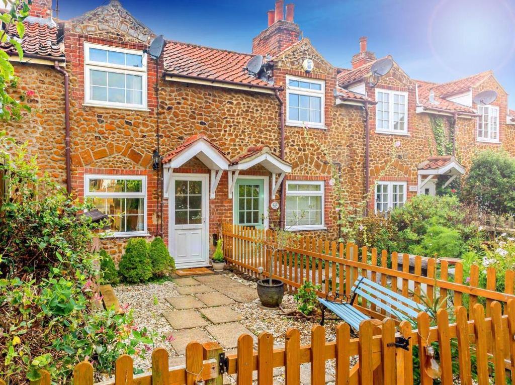 a brick house with a wooden fence and a bench at 2 Bed in Dersingham oc-p28040 in Dersingham
