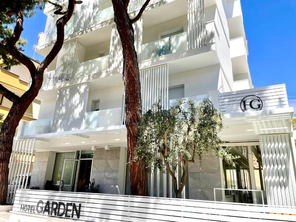 a white building with trees in front of it at Hotel Garden in Riccione