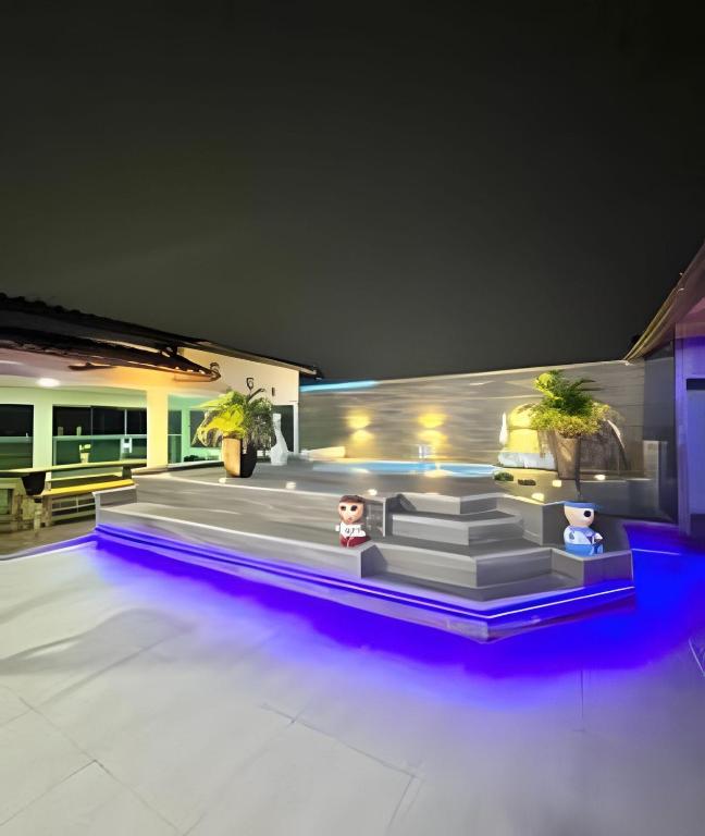 a house with a pool with purple lights at Cobertura com piscina, sauna e churrasqueira in São Pedro da Aldeia