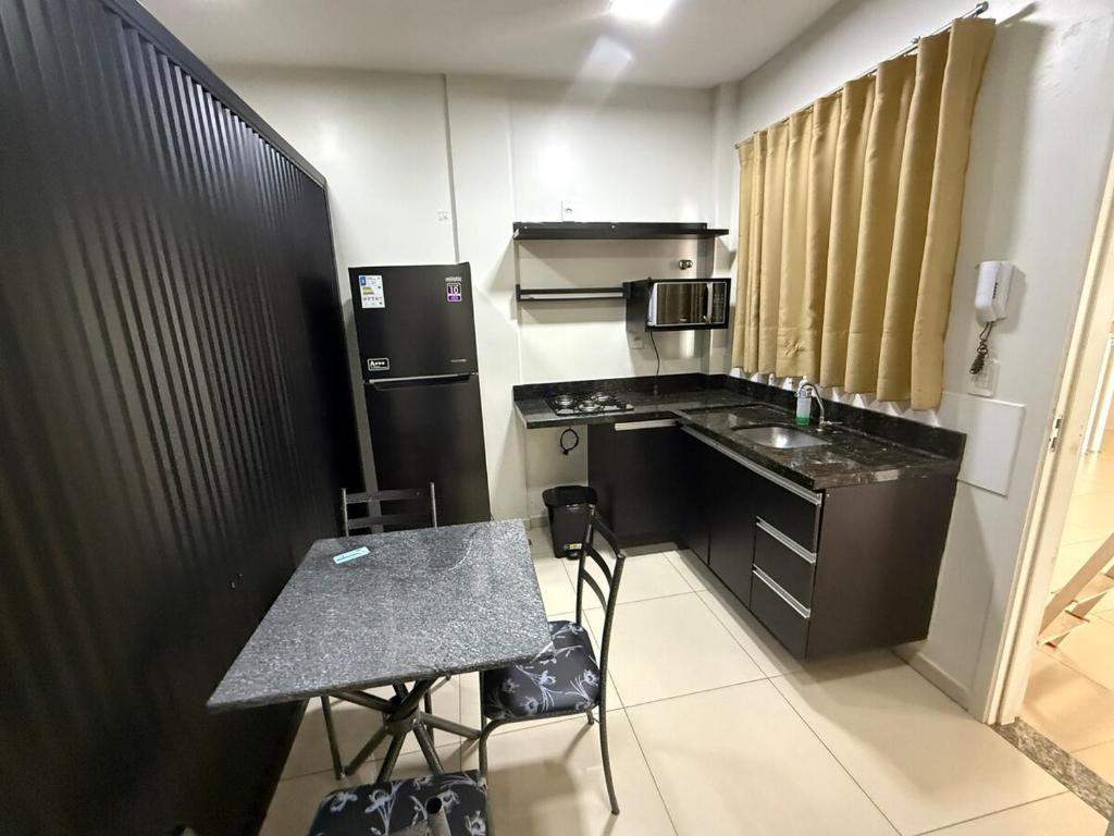 a small kitchen with a table and a counter top at Fitroom Apartment in Santarém