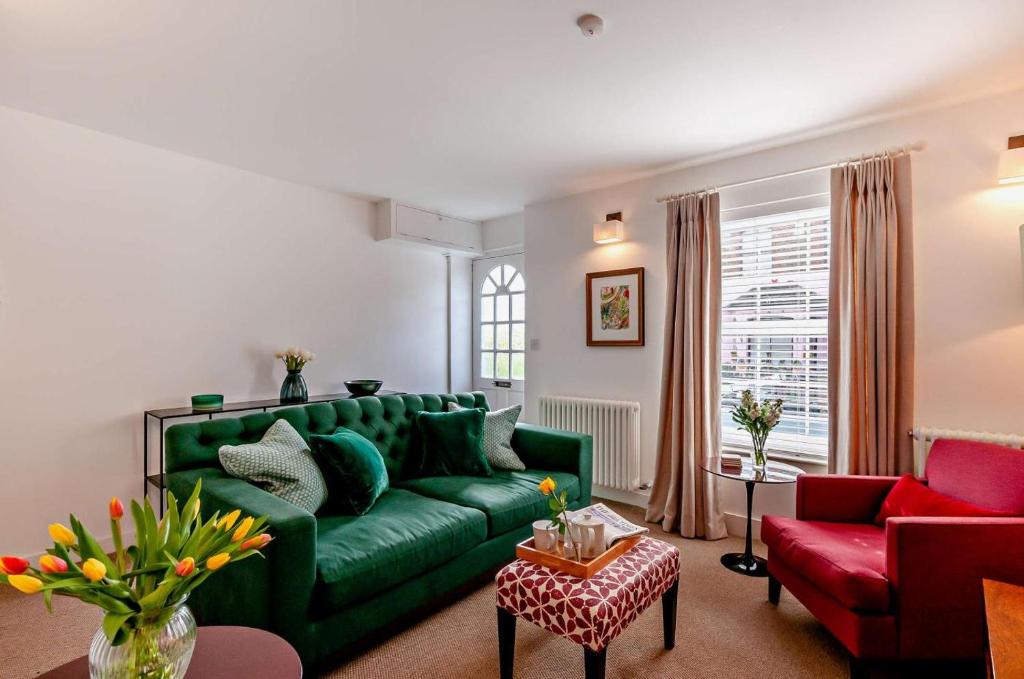 a living room with a green couch and red chairs at 4 Bed in Walmer oc-c29264 in Deal