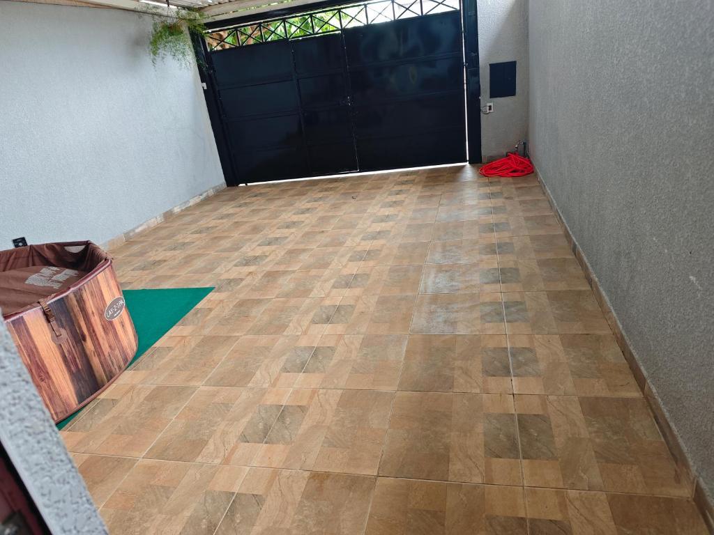 a hallway with a garage door and a wooden floor at Quarto casal Px aeroporto Garagem in Cascavel